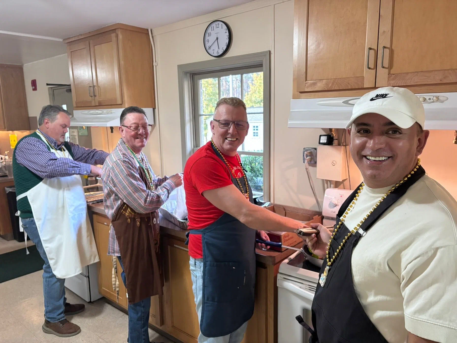Four men cooking breakfast together in the parish kitchen.