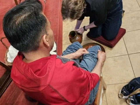 A parishioner washing another's feet on Maundy Thursday.